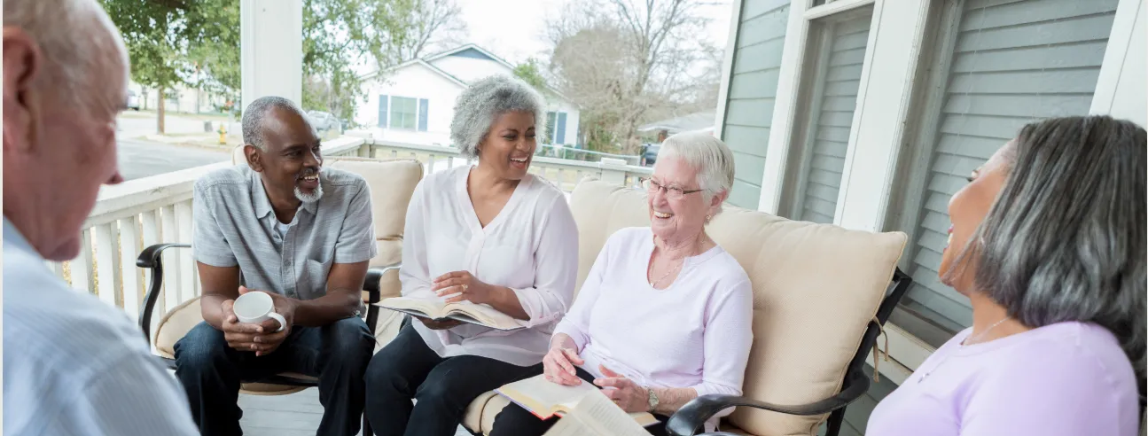A diverse group of older adults gathered in conversation on a porch